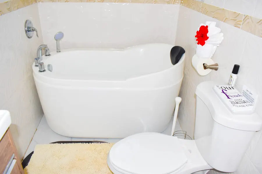 Freestanding soaking tub with a red hibiscus on folded towels