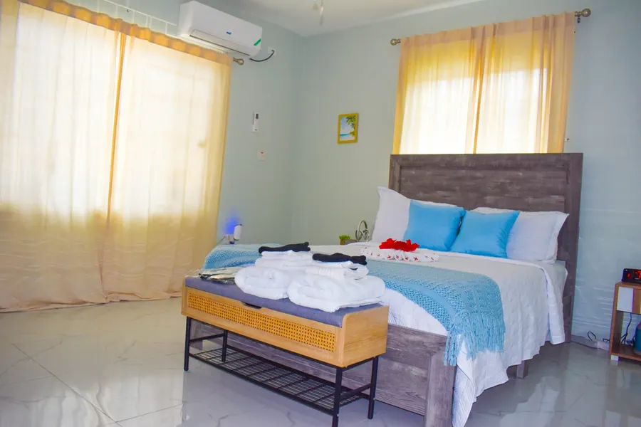 Second bedroom with a queen bed dressed in a pale blue throw